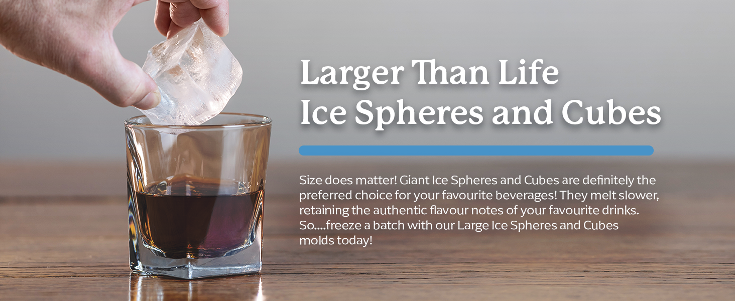 large ice cube being placed in a glass with scotch