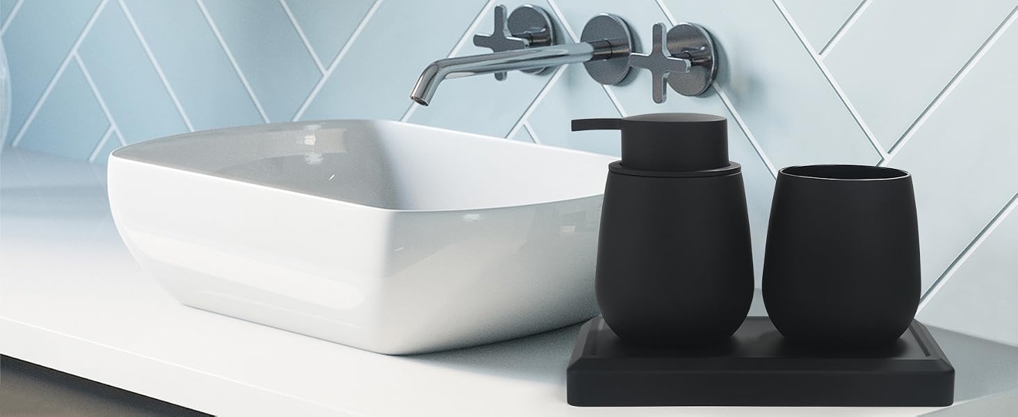 Modern bathroom sink with rectangular white basin, wall-mounted faucet, and black bathroom accessories including soap dispenser and toothbrush holder on a black tray.