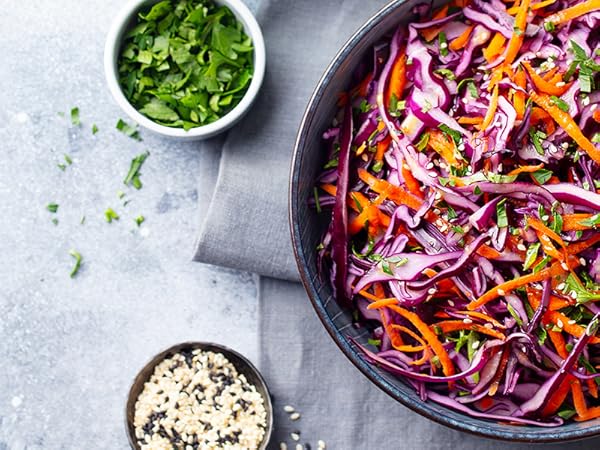 a bowl of red cabbage salad with a bowl of chopped cilantro and a bowl of coriander.
