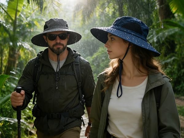 Couple in waterproof sun hats hike in a rainy jungle. Durable safari hat for wet outdoor trips.