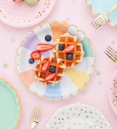 Colorful segmented paper plates with gold foil edges and waffles for vibrant party celebrations.