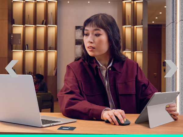 a woman on a laptop and holding a tablet in her hand