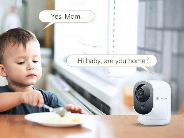 Indoor security camera on a table, with speech bubbles showing a conversation. A child is partially visible in the foreground.