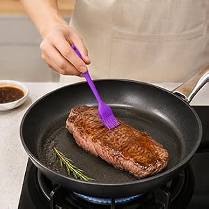 purple silicone brush applying sauce to steak