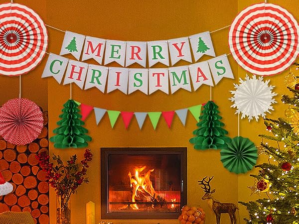 Festive Christmas scene with decorated tree, fireplace, and colorful paper decorations including 'Merry Christmas' banner on orange background.
