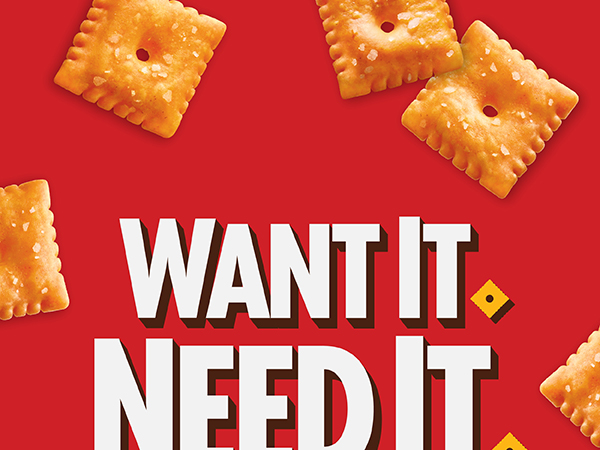 Want It. Need It. Cheez-It logo on a red background with a scattering of Original Cheez-It crackers