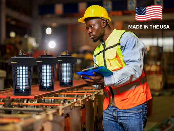 Male factory worker holding a clipboard inspecting three bug zappers