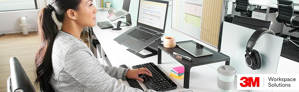A woman at her desk with 3M workspace solutions around her