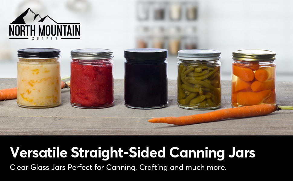 five straight sided canning jars lined up on counter with various contents and carrots