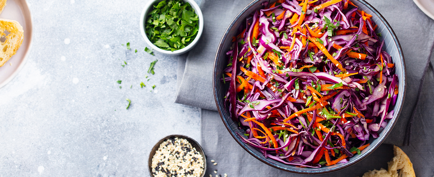 a bowl of red cabbage salad with a bowl of chopped cilantro and a bowl of coriander.