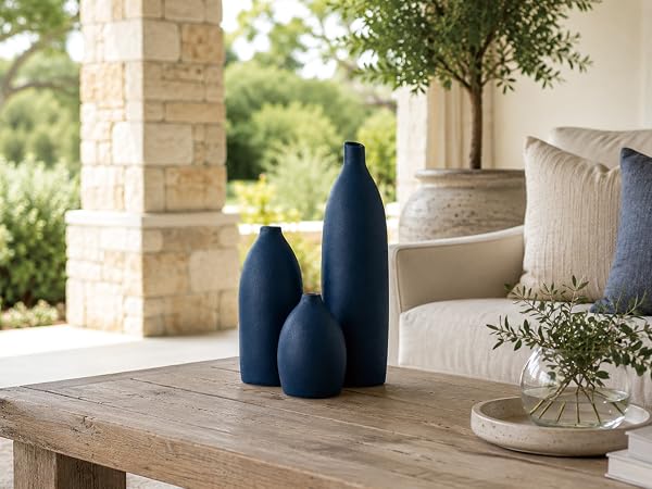 Matte coastal blue ceramic vase set on a wood console table with dried flowers.