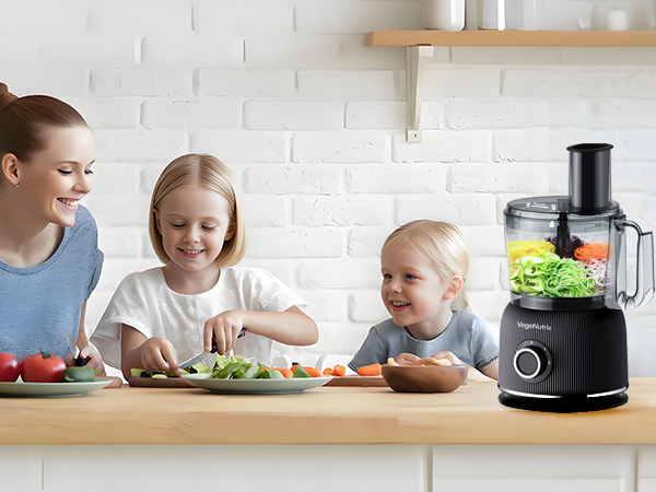 Family kitchen scene with children helping prepare food using a food processor. Multiple images showing various stages of food preparation on a white countertop against brick wall background.