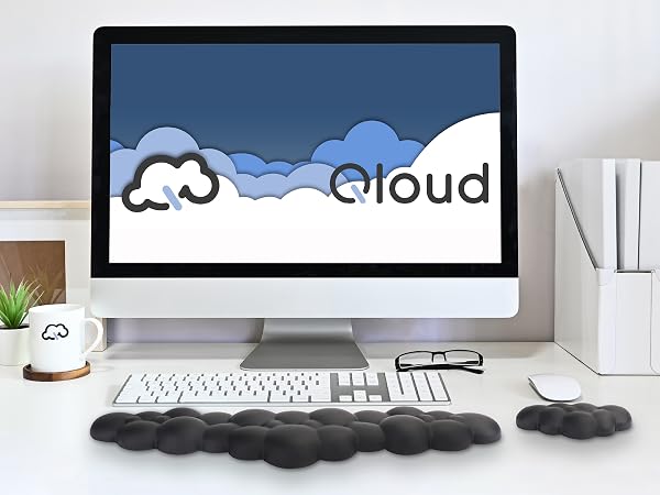 Black cloud wrist rest and mouse wrist rest on neat desk in front of computer with natural lighting