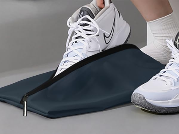 Dark blue or black compression sleeve or wrap shown with white Nike athletic shoes, demonstrating wear or application on lower leg.
