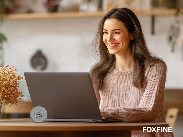 Woman working at desk with FOXFINE beside her, supporting concentration