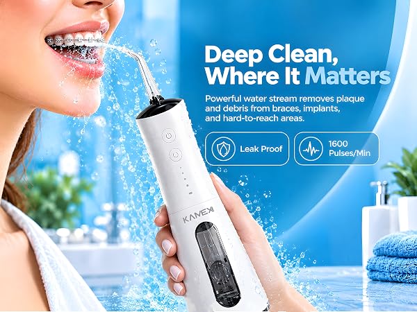 A woman with braces smiling while using water flosser on her teeth.
