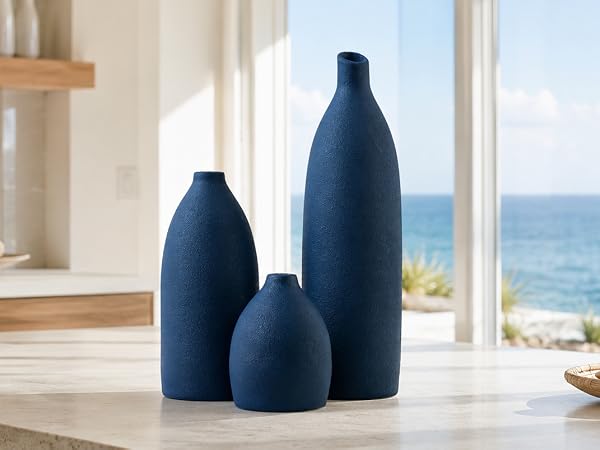 Matte navy blue vase set on a wooden coffee table in a bright coastal living room. ?3 Alt Text: