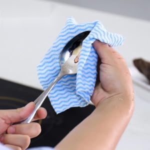 a person holding a spoon and a cloth.