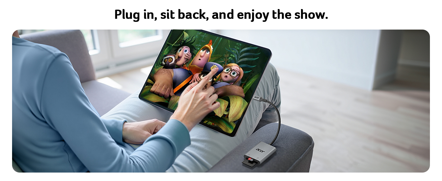 A person using a tablet device displaying colorful animated characters. A USB drive is plugged into the tablet, suggesting media playback functionality.