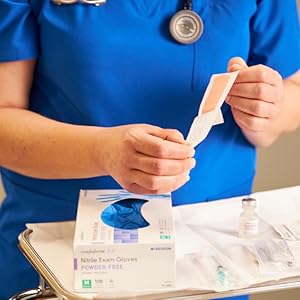 Nurse opening Sterile Adhesive Bandage to apply on a patient