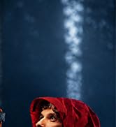 Red bicycle helmet with reflective details against dark blue background with bokeh light effects, showcasing safety visibility features.