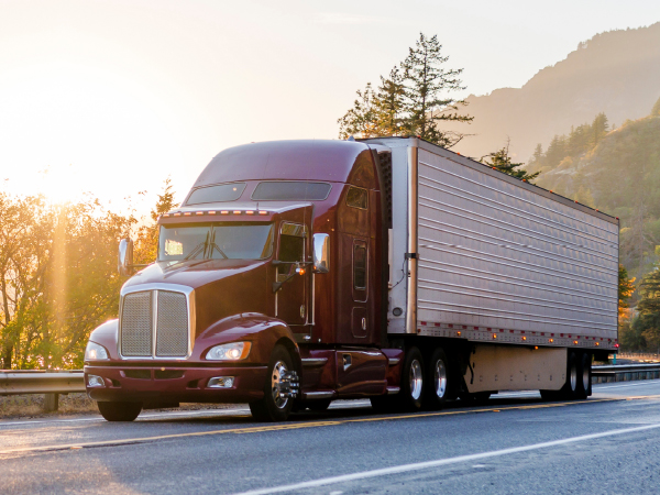 truck driving with trees in background