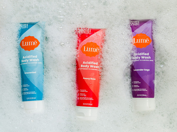 Lume Acidified Body Wash in Unscented, Peony Rose and Lavender Sage scents floating in a bath tub