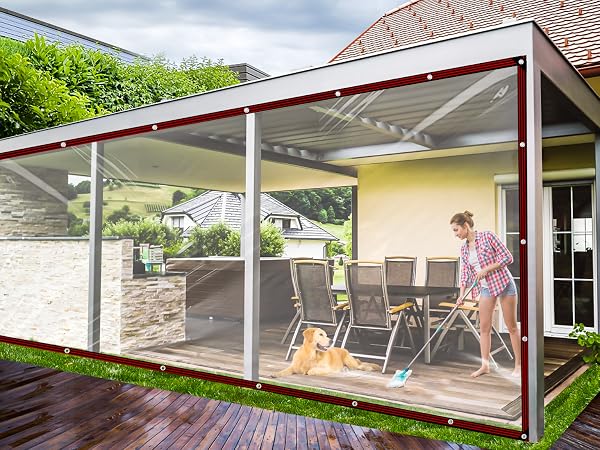 Outdoor patio cover with retractable clear screens, mounted on wooden deck. Features white support posts and brown trim along transparent panels.