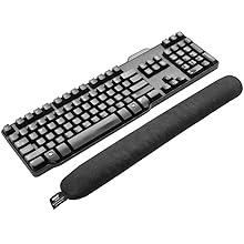 Multiple views of a minimalist mechanical keyboard with a wrist rest, showing full and partial angles of the black device.