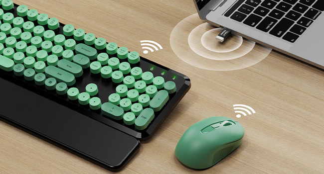 Green Black round-key keyboard and mouse connected wirelessly to a laptop with a USB receiver.