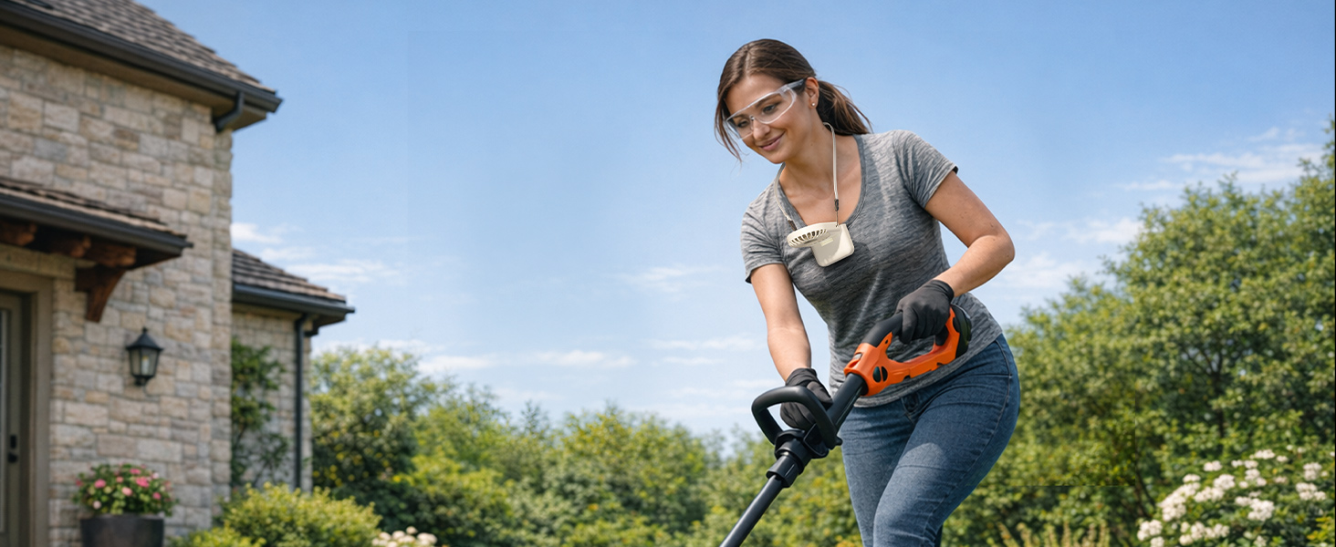 Woman outdoors at wooden structure using handheld power tool on wooden post. She wears grey sleeveless shirt and dark pants against blue sky and green foliage background.