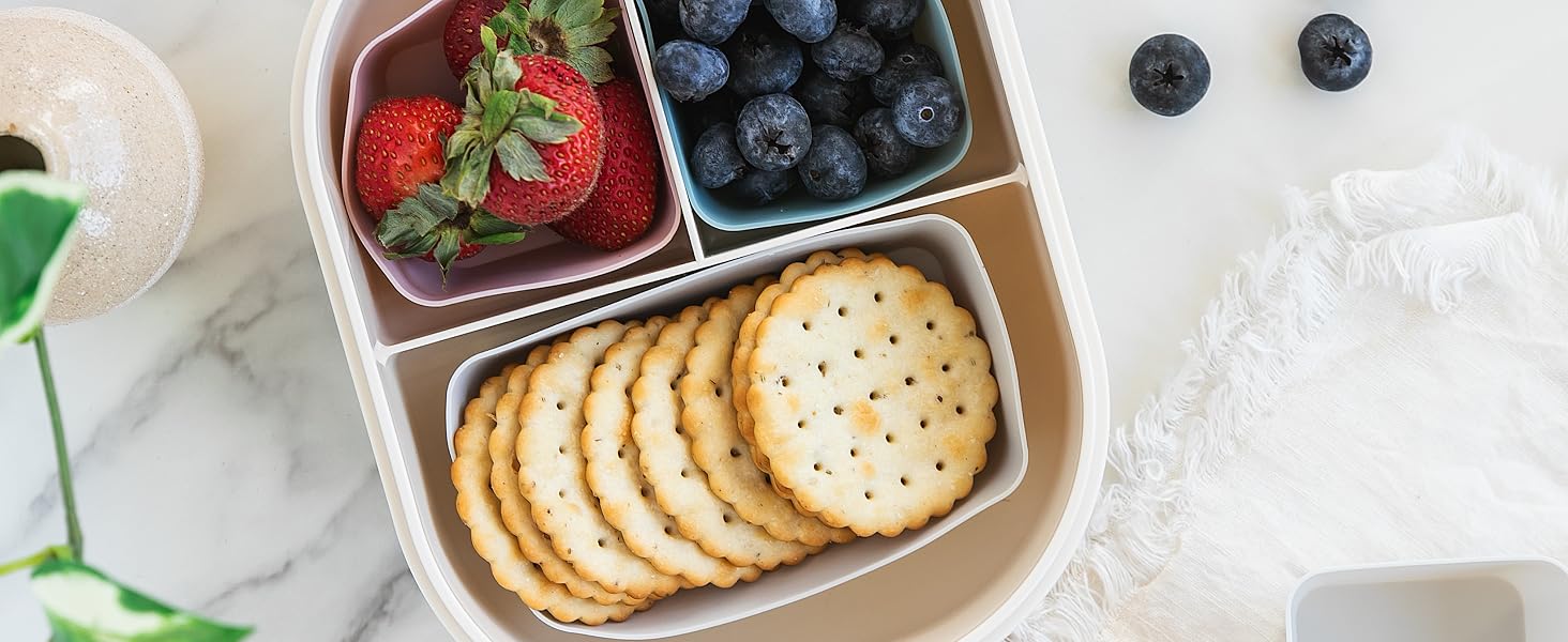 Silicone baking cups in a lunch box sorting snacks, crackers, fruit