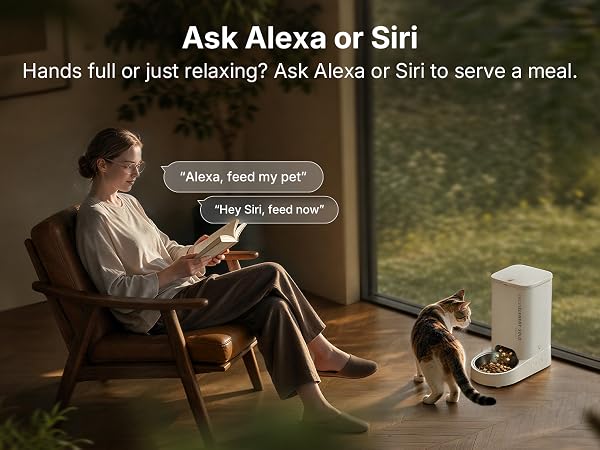Text reads 'Ask Alexa or Siri' and 'Hands full or just relaxing? Ask Alexa or Siri to serve a meal.' White cylindrical smart speaker with woman seated in chair holding device, speech bubbles showing voice commands.