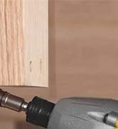 Close-up of a power drill being used on unfinished wood, likely during a home improvement or furniture assembly project.