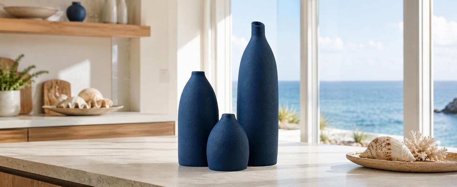 Matte navy blue vase set on a wooden coffee table in a bright coastal living room. ?3 Alt Text: