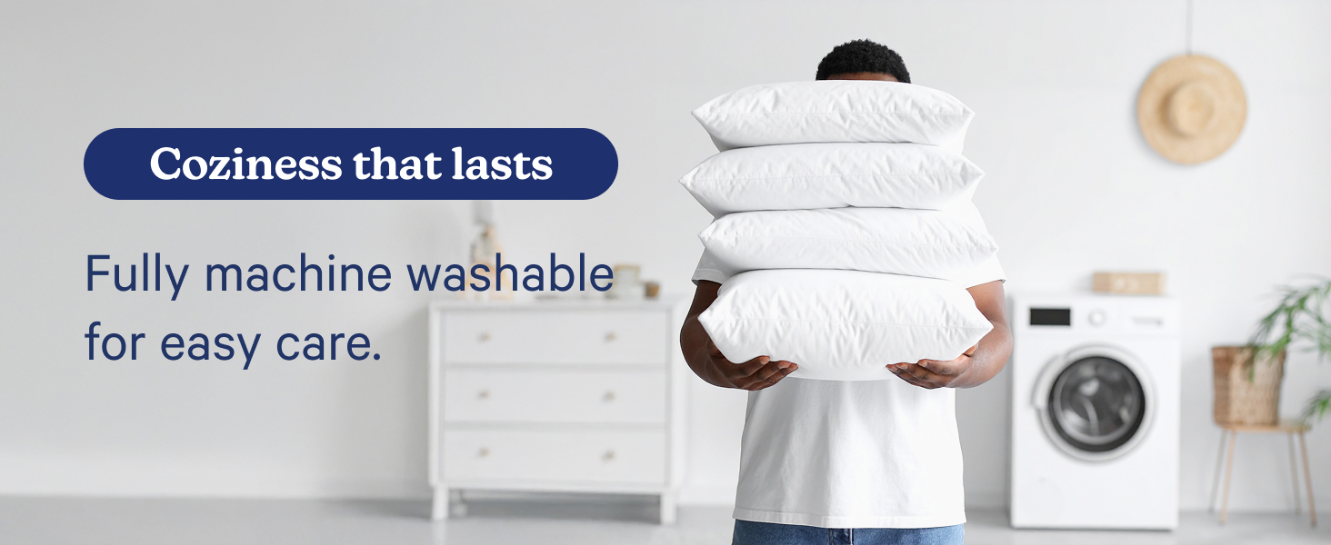 person holding stack of pillows in front of washing machine