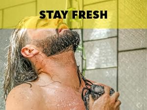 man using loofah in the shower with body wash