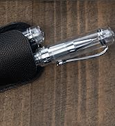Close-up detail of a silver metallic mechanical device or tool component resting on a dark wooden surface.