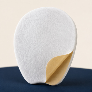 Macro view of white cotton-blend felt pad and peel-back adhesive.