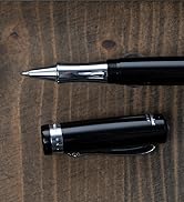 Black pen or writing instrument shown in multiple angles against dark wooden surface, displaying sleek metal clip and cylindrical design.