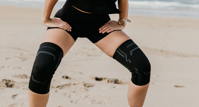 Woman running on a beach in BODYPROX Knee Sleeves