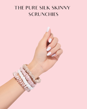 Hand wearing multiple thin silk hair scrunchies in pastel colors. Scrunchies are stacked on wrist, showcasing their slim profile and delicate appearance.