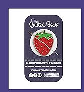 Text reads: 'The Quilted Bear' and 'MAGNETIC NEEDLE MINDER' and 'WWW.QUILTEDBEAR.CO.UK'. Product shows strawberry-shaped needle minder with silver needle against dark background.