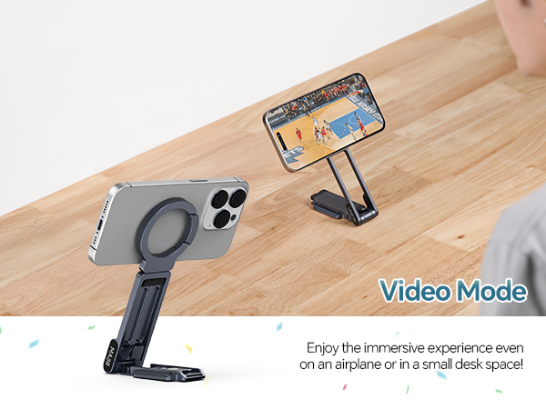 Text reads 'Video Mode'. Product shows phone holder or stand with adjustable arm on wooden surface, displaying mounted smartphones.