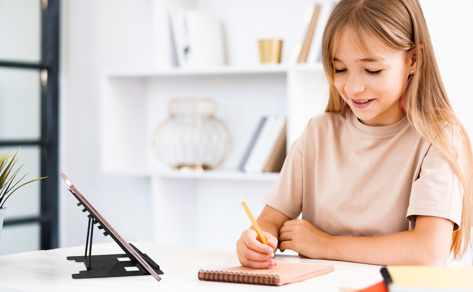 a young girl writing on a notebook