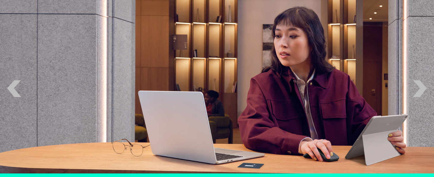 a woman on a laptop and holding a tablet in her hand