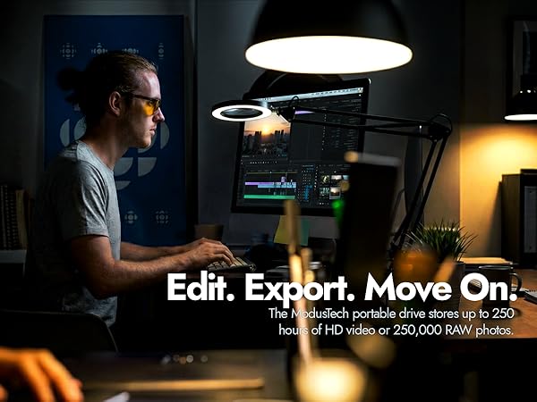 Video editor at desk using video editing software with ModusTech Facet drive for 4K video storage