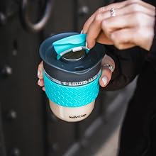 a woman holding a coffee cup in her hand.