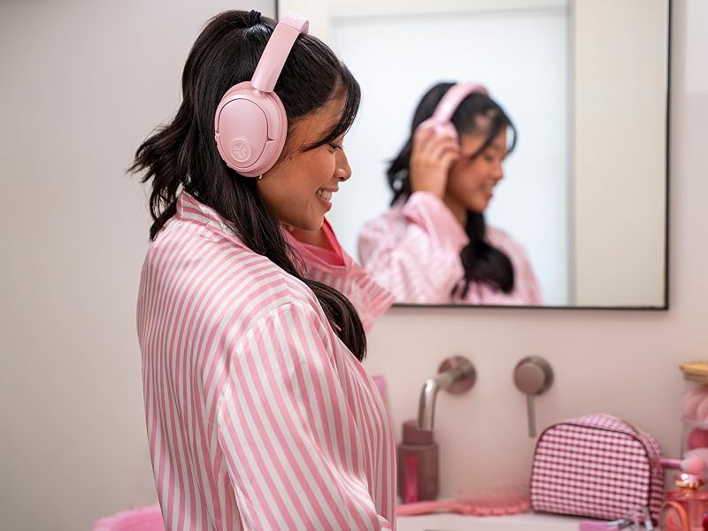 Woman doing her makeup while wearing jlab headphones