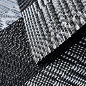 Close-up of textured fabric or material with a repeating pattern of parallel lines and ridges, creating a geometric design.